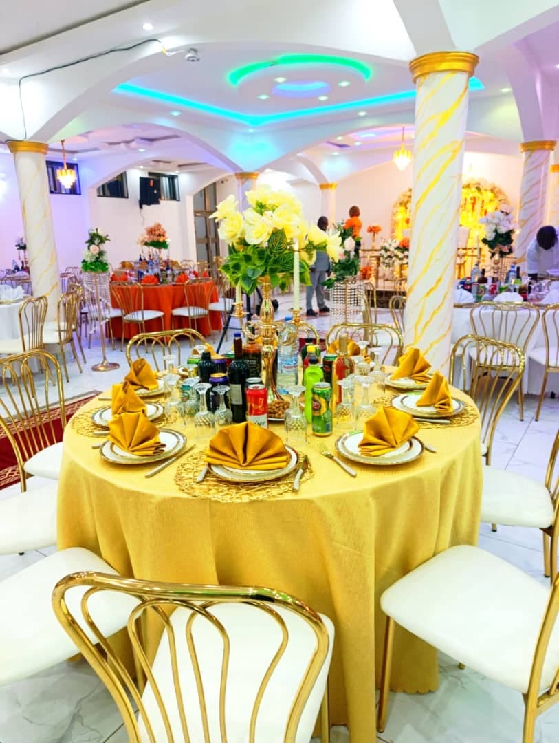 Table dressée en or avec serviettes en éventail et centre de table floral dans la Salle Haut de Gamme
