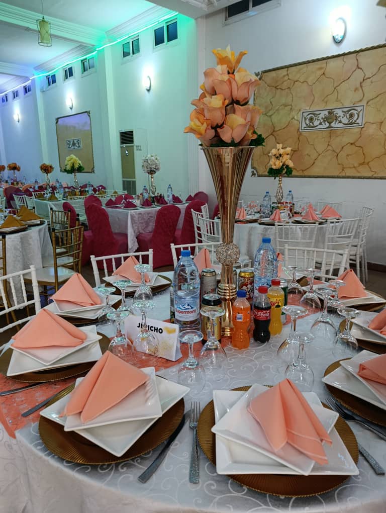 Centre de table floral pêche sur pied doré et couverts dressés dans la Grande Salle Prestige